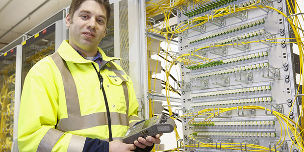 Ein Mitarbeiter steht vor einer Wand mit mehreren Kabelverbindungen