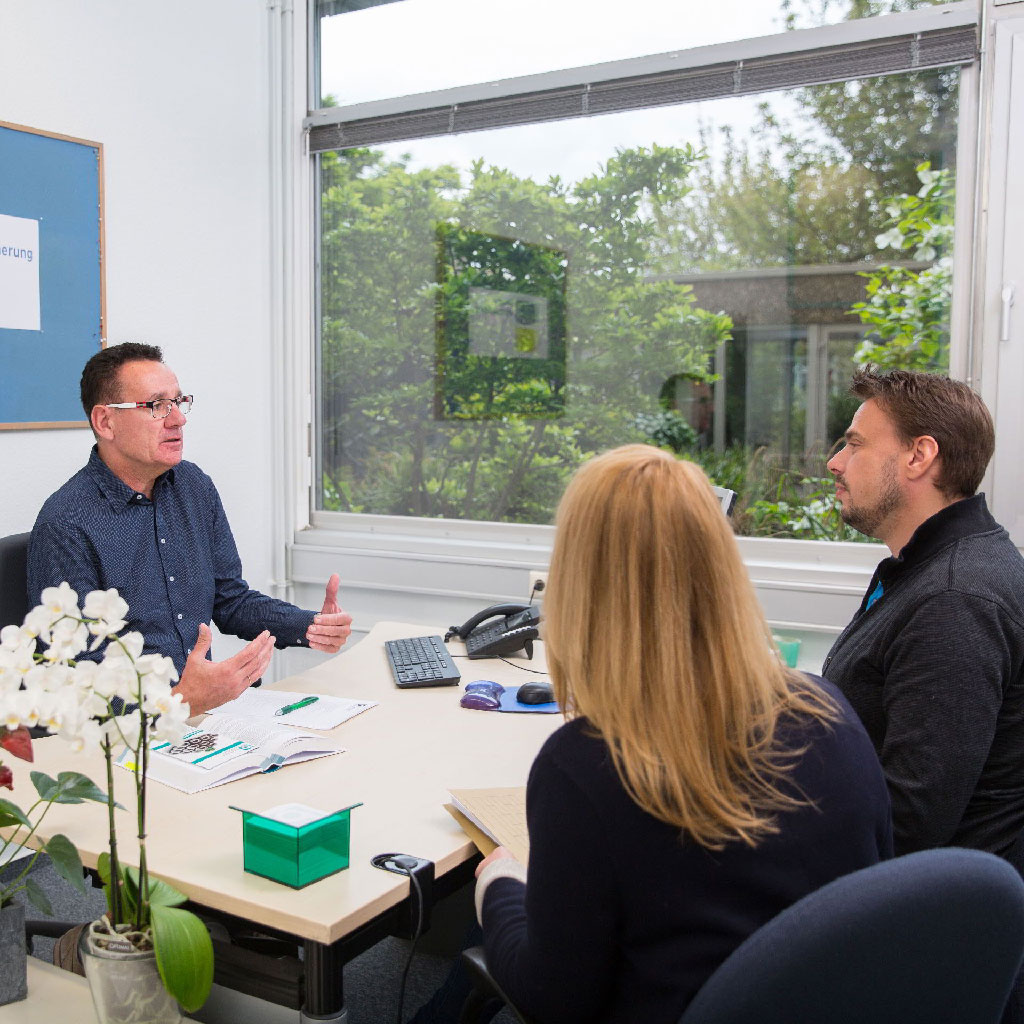 Drei Personen im Büro im persönlichen Beratungsgespräch